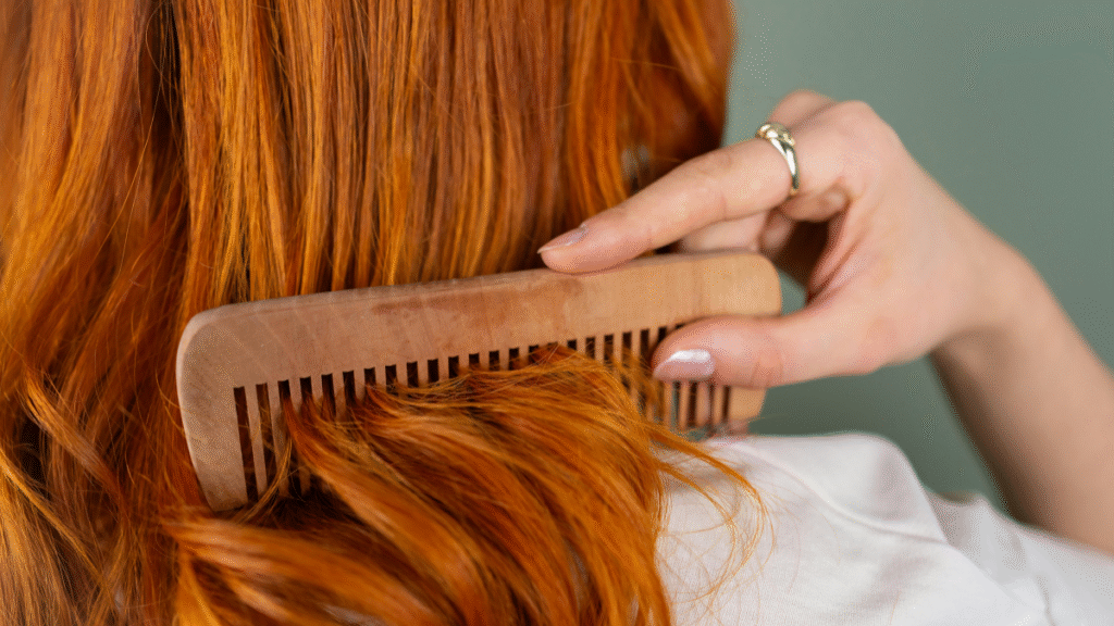 Pessoa aplicando Óleo DaBelle Abacate nas pontas do cabelo para nutrição e controle do frizz.